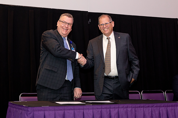 two men shaking hands on a table