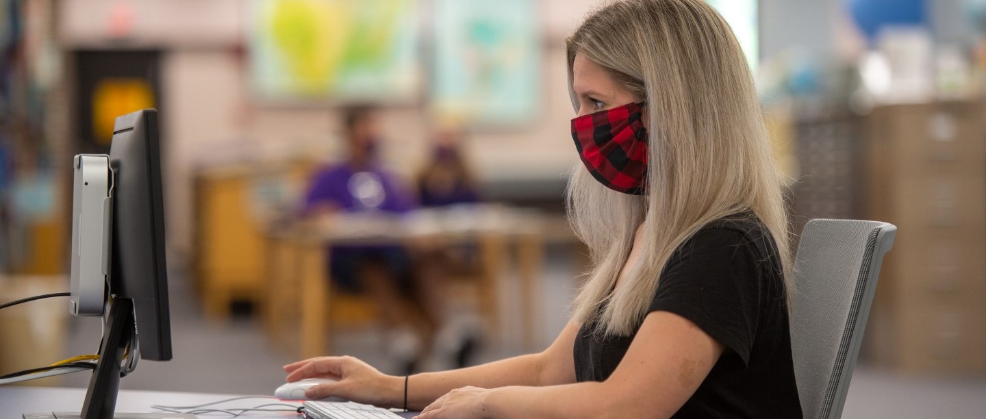 Student with mask using computer